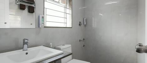 A modern bathroom with a sink, toilet, and shower.