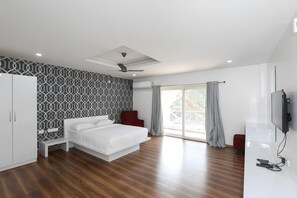 A modern bedroom with a bed, wardrobe, ceiling fan, and a TV.