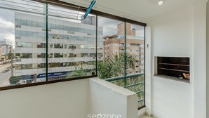 Ein Balkon mit Blick auf ein modernes Gebäude, einer kleinen Ablage und einer Deckenleuchte.