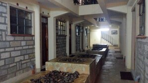 A corridor with stone walls, a fireplace, and a staircase leading to an upper level. - The Exotic House Kericho (Kericho)