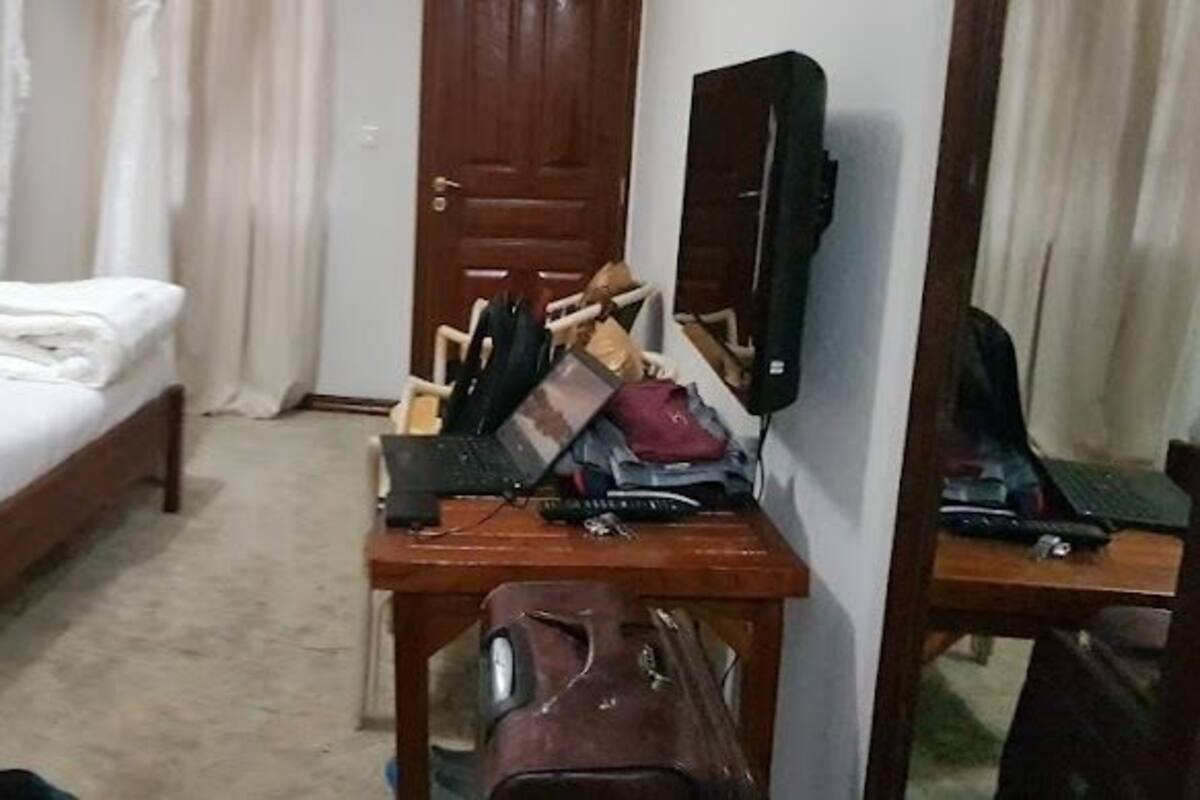A hotel room with a bed, a desk, a chair, a wardrobe, and a TV.