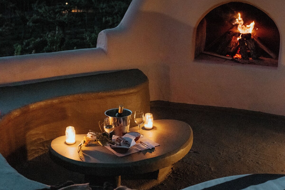 Un área de estar al aire libre con una mesa, velas y un brasero.