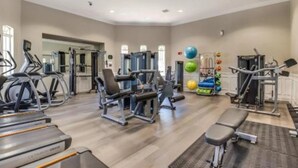 A gym with treadmills, weight machines, and exercise balls.