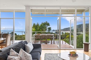 A spacious living area with a large sliding glass door leading to an outdoor patio. - Coastal Style (Lorne)