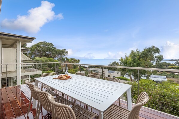 A dining area with a table and chairs, overlooking a scenic view.