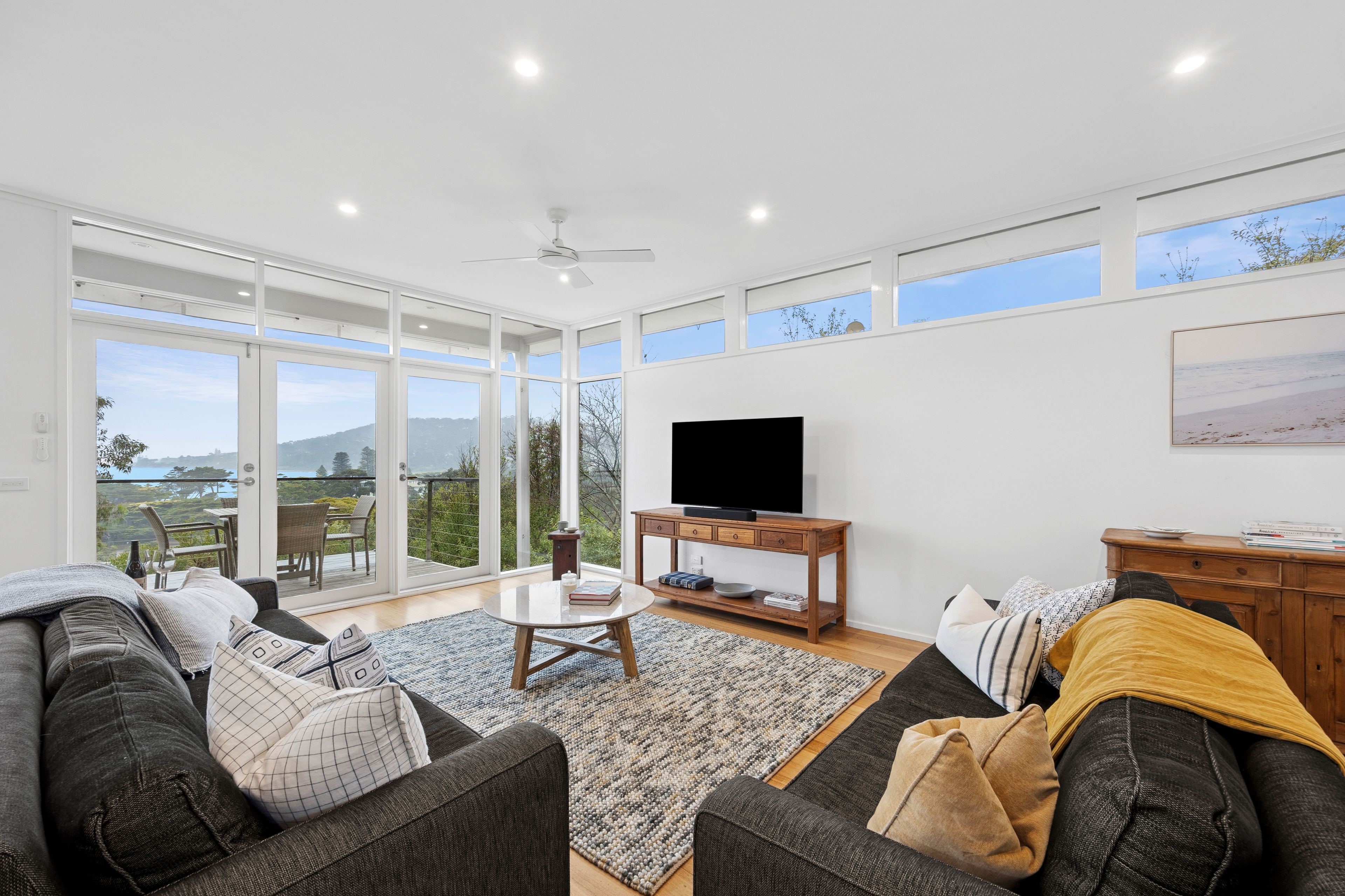 A spacious living area with a large TV, comfortable seating, and a view of the outdoors.