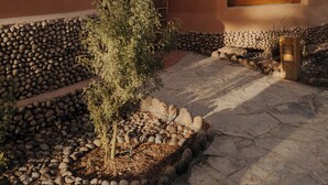 Un bâtiment rustique avec un toit de chaume, une porte en bois et une fenêtre ornée de rideaux.