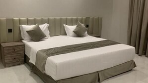Un dormitorio moderno con una cama grande, una mesita de noche de madera y un aire acondicionado de pared.