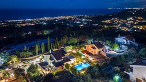 A residential area with houses, a swimming pool, and a view of the sea at night. - 'Picahouse' Apartment with Sea View, Wi-Fi & Air Conditioning near Cefalù (Sant'Onofrio)