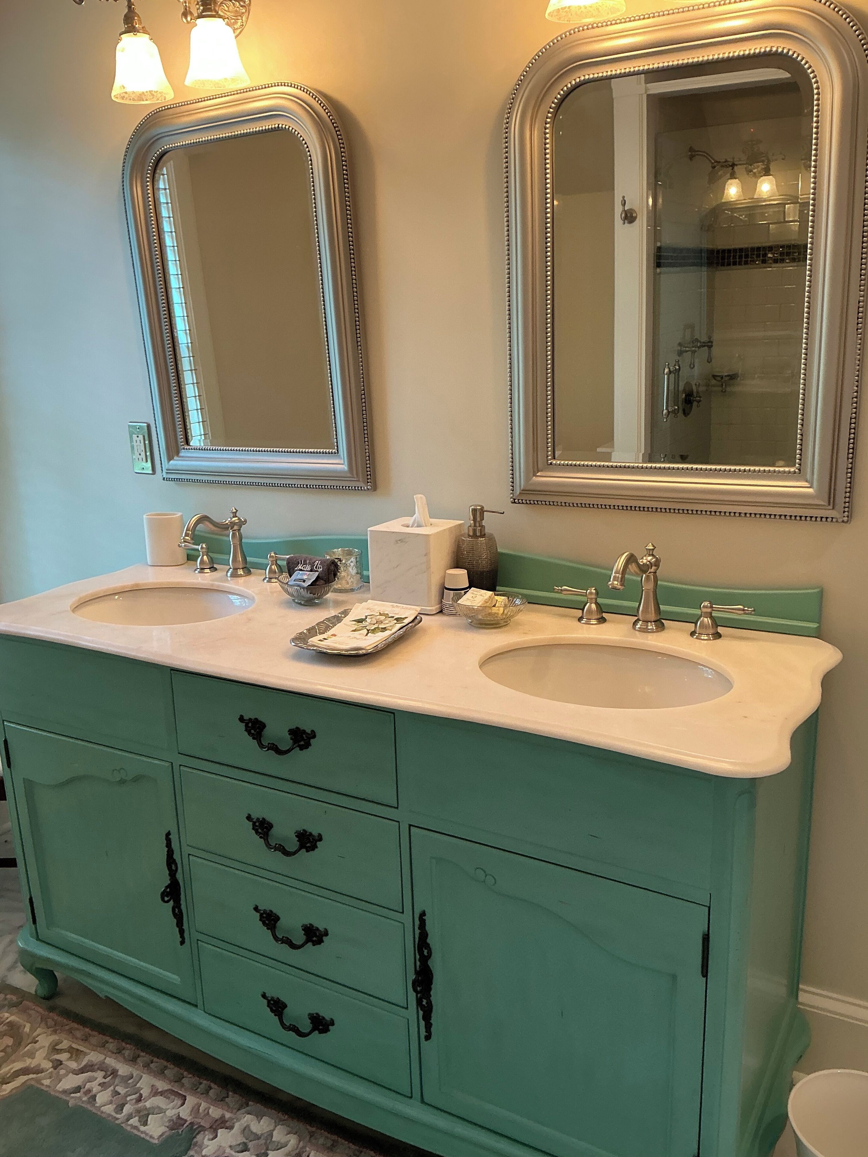 A bathroom with two sinks, a vanity, and two wall-mounted mirrors.