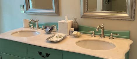 A bathroom with two sinks, a vanity, and two wall-mounted mirrors.