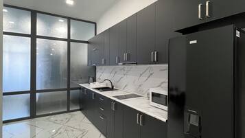 Departamento clásico, balcón | Cocina privada | Microondas, parrilla de estufa, tetera eléctrica y utensilios de cocina