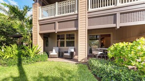 A two-story building with a covered patio area featuring outdoor seating.