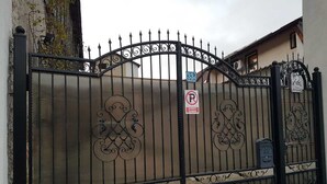 Een hekpoort met een 'Geen Parkeren'-bord, een brievenbus en een gebouw met de tekst 'Casa Beretta'.