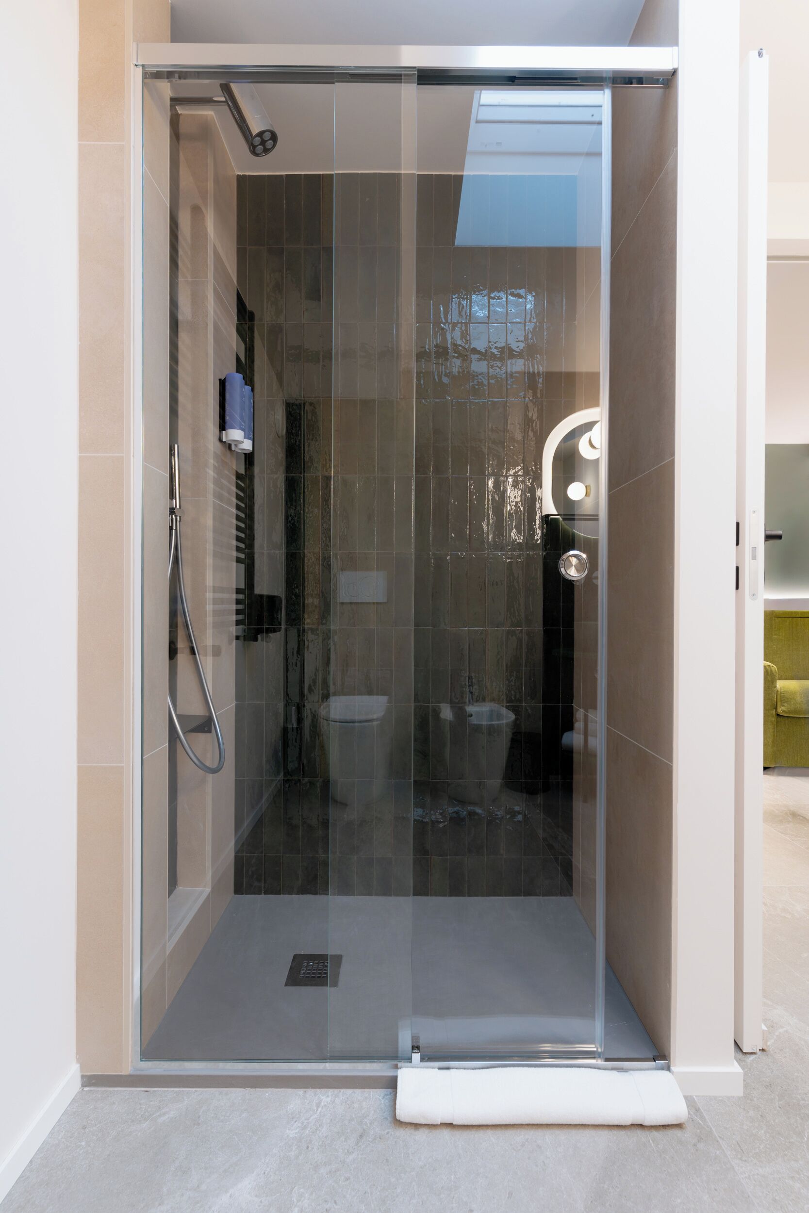 Un baño moderno con ducha acristalada, inodoro y lavamanos.