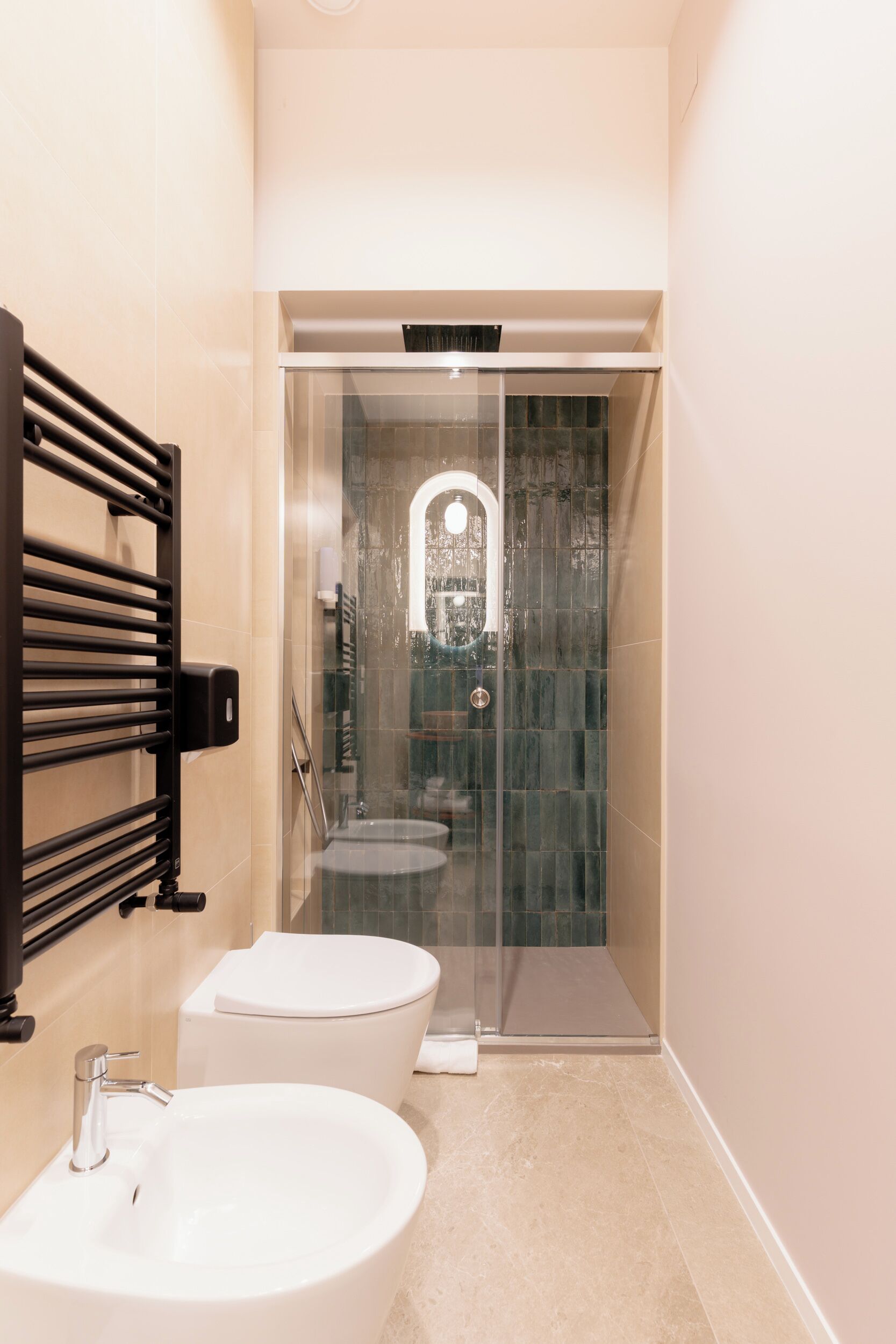 A modern bathroom with a glass-enclosed shower, a white sink, and a toilet.