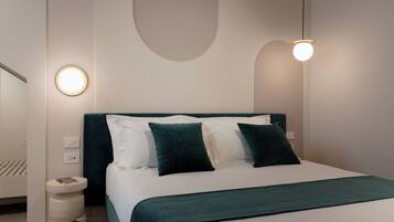 A modern bedroom with a bed, bedside tables, and a wall-mounted light fixture.