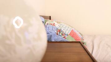 Een bed met een kleurrijke quilt en een houten hoofdbord.
