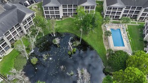 Un quartier résidentiel doté d’une piscine, d’un étang et de plusieurs immeubles avec balcons.