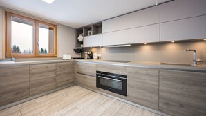 Una cocina moderna con electrodomésticos integrados, una ventana y un tragaluz.