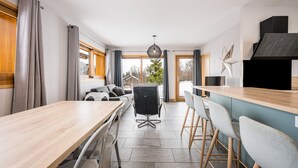 Eine moderne Küche mit Essbereich, einem großen Fenster und Blick ins Freie.