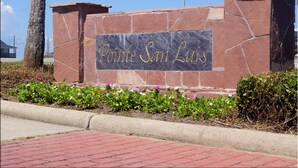Un letrero de piedra con la inscripción 'Pointe San Luis' grabada en letras doradas.