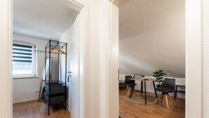 A room with a bed, a desk, a chair, and a window with blinds.