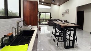 A modern kitchen with a built-in oven, a sink, and a bright yellow towel. - Barefoot (Bijagua de Upala)