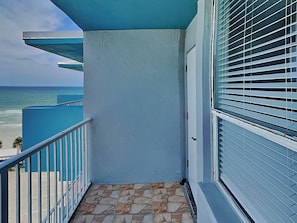 A balcony with a view of the ocean, a tiled floor, and a blue railing. - The Salty Fountain by Distinctive Beach Rentals (Daytona Beach)