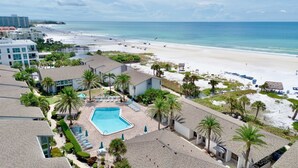 A resort with a swimming pool, beach access, and palm trees. - Peppertree #507- Private Access (Siesta Key)