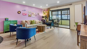 A living room with a sofa, two blue armchairs, a coffee table, and a green cabinet. - Peppertree #507- Private Access (Siesta Key)