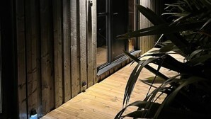 Eine Holzausfachung mit einer Glastür, die zu einem Holzboden führt.