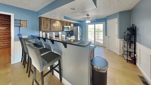 Una cocina moderna con barra, armarios de madera y vistas al exterior.