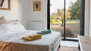 A bedroom with a bed, a bench, a window, and a view of the outdoors. - Guest Room "Room 2" with Mountain View, Shared Pool and Wi-Fi (Aléria)