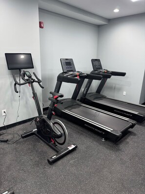 Ein Fitnessstudio mit zwei Laufbändern und einem Ergometer.