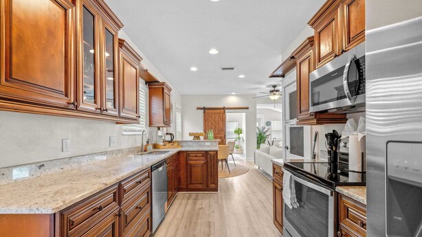 Una cocina con armarios de madera, electrodomésticos de acero inoxidable y una isla central.