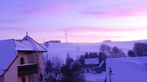 Schneelandschaft mit Gebäuden und einem Strommasten.