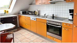 Eine Küche mit Mikrowelle, Toaster, Kaffeemaschine und Backofen.