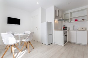 A modern kitchen with white cabinetry, a built-in oven, and a microwave.