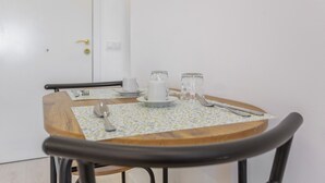A dining table with a floral tablecloth, a wooden chair, and a white door in the background.