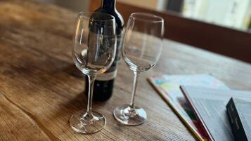 A wooden table with a wine bottle and two wine glasses.