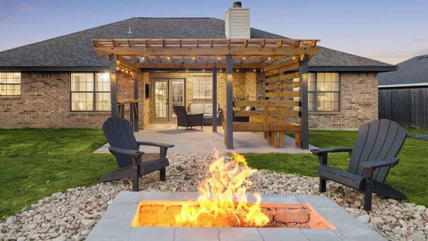 A patio with a fire pit, outdoor seating, and a pergola. - Backyard Oasis: Smart Home w/ Alexa & Fire Pit (Killeen)