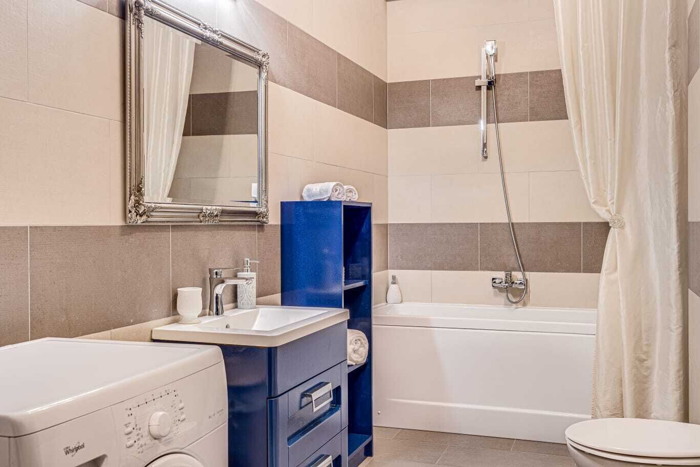 A modern bathroom with a sink, mirror, and shower.