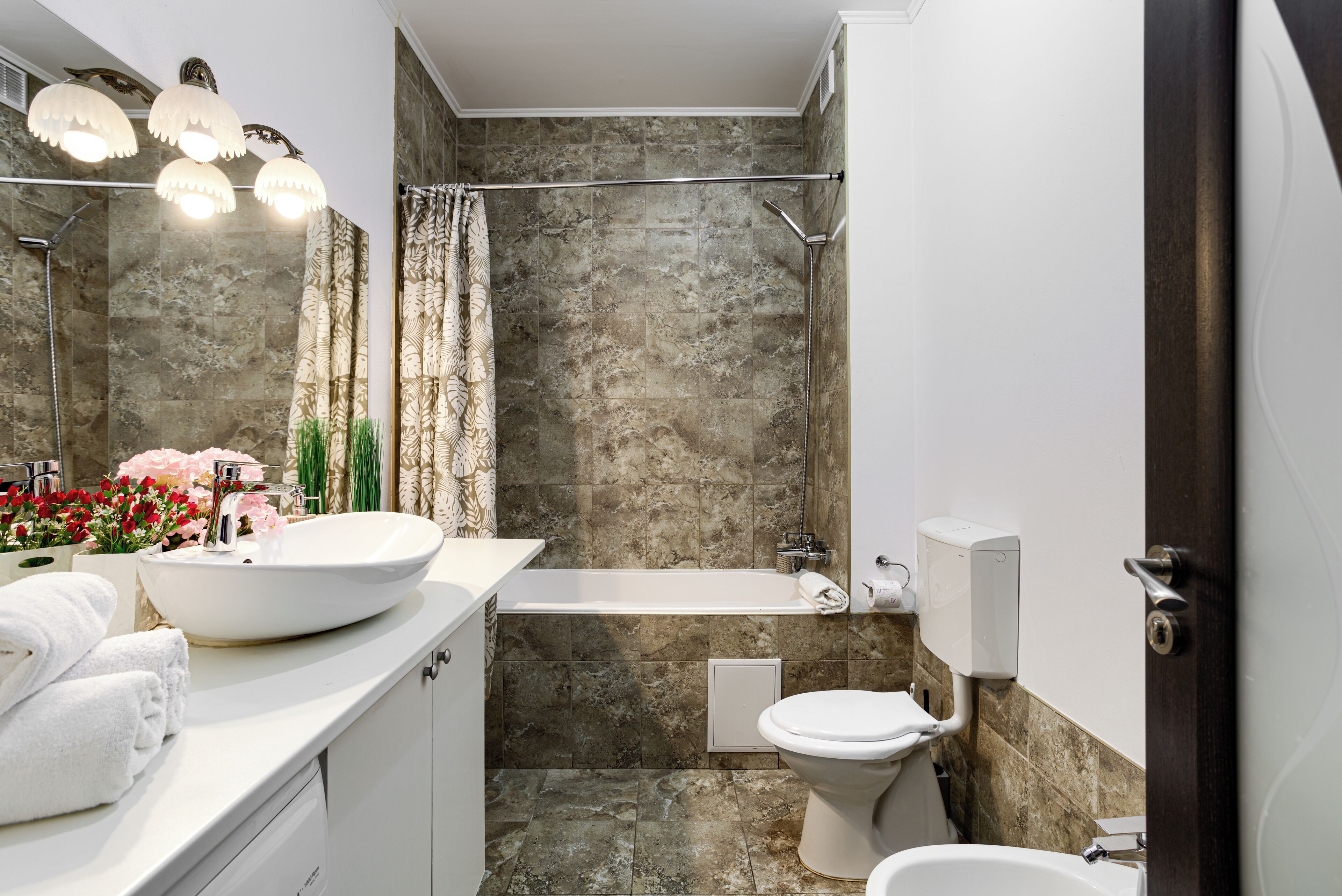 Un baño moderno con un lavamanos grande de color blanco, una bañera y un inodoro.