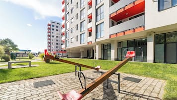 A seesaw in a courtyard with a modern building in the background.