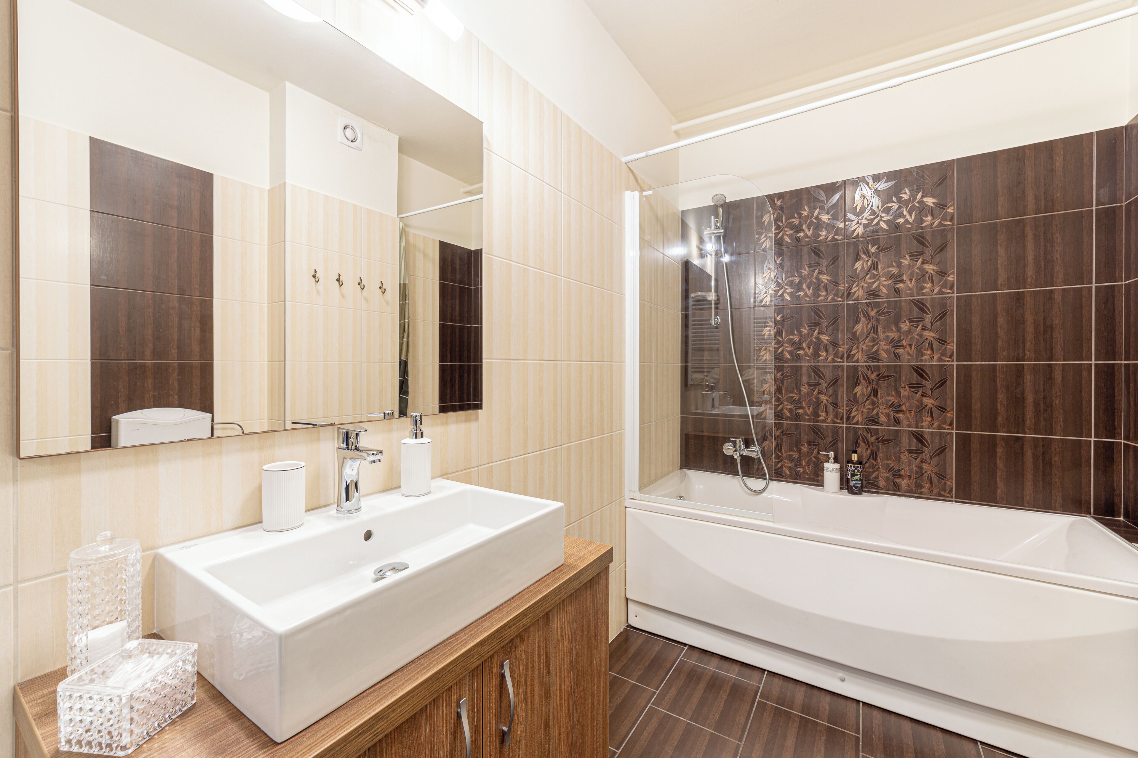 Un baño moderno con un lavamanos grande de color blanco, un espejo y una bañera.