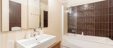 Un baño moderno con un lavamanos grande de color blanco, un espejo y una bañera.