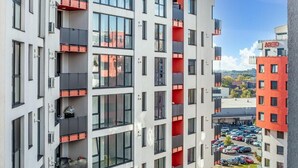 A multi-story building with balconies, a parking area below, and a clear sky. - ARI - ARED Luxurious Apartments (Arad)