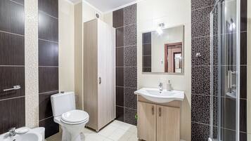 Un baño moderno con inodoro, lavabo y ducha.