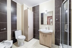 Un baño moderno con inodoro, lavabo y ducha.